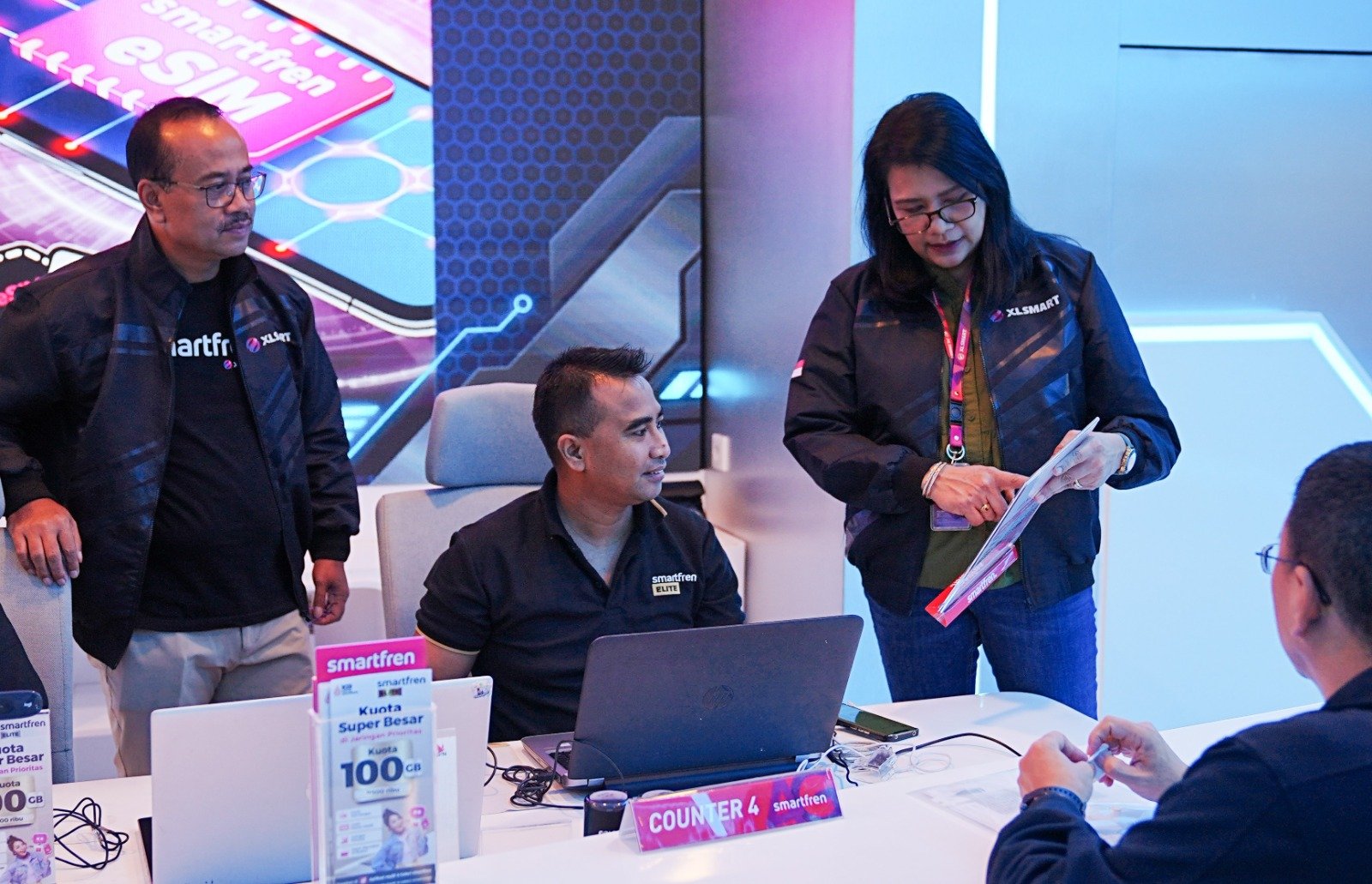 Chief Marketing Smartfren Officer XLSMART, Sukaca Purwokardjono (kiri), petugas Customer Care Galeri Smartfren (tengah) bersama Head Customer Succes XLSMART, Rochelle Camasosa (kanan) sedang memberikan pelayanan kepada pelanggan di Galeri Smartfren, Jumat (18/7/2025).