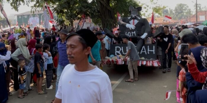 Suasana Warga Menes menampilkan Ornamen satir tikus raksasa bertuliskan “Rp 40 Miliar Runtah (Sampah)” di acara karnaval pada perayaan HUT RI ke-80 tahun.
