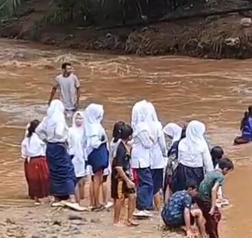 Puluhan Pelajar SD dan SMP di Kampung Cegog, Desa Rancapinang, Kecamatan Cimanggu, Kabupaten Pandeglang, harus menyebrang sungai arus deras menuju sekolah.