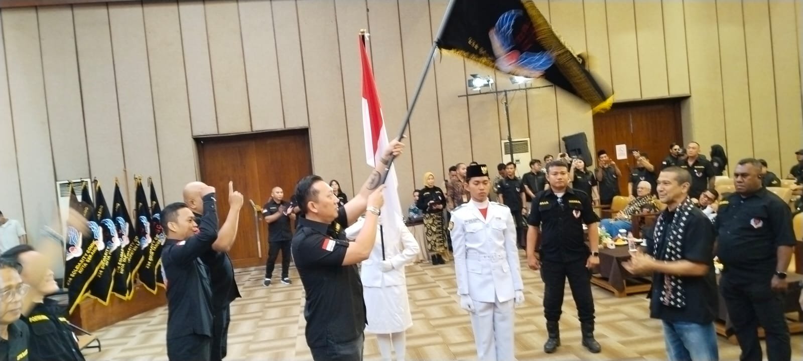 Ketua DPW 234 SC tovinso Banten Kian Maulana mengibarkan bendera usai dilantik, Jumat (23/1/2026).