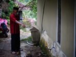 Warga sedang melihat adanya retakan di rumah Warga sedang melihat adanya retakan di rumah