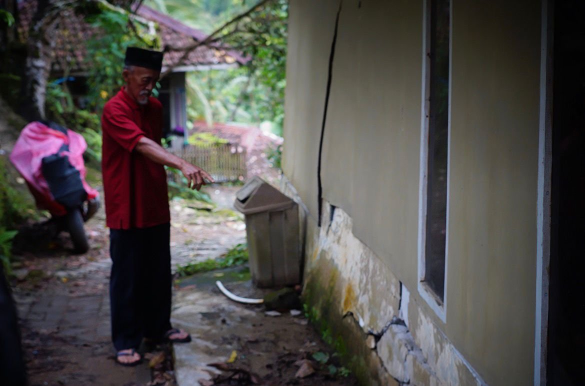 Warga sedang melihat adanya retakan di rumah