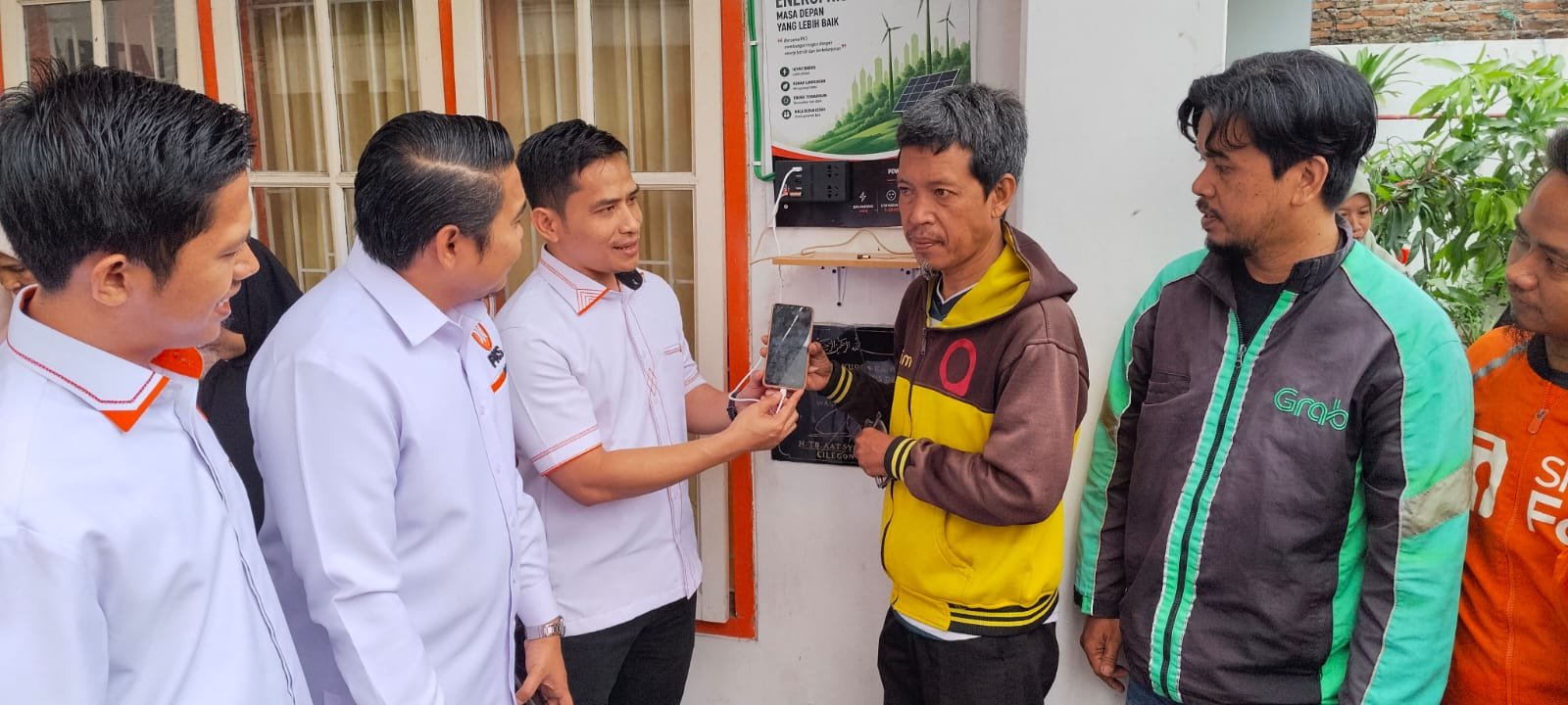 Ketua DPD PKS Kota Cilegon Ferry Budiman berdama pengurus keresmikan gerai charger tenaga surya bersama para Ojol.
