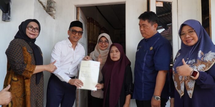 Caption : Bupati Pandeglang, Raden Dewi Setiani saat menyerahkan Sertifikat Hak Atas Tanah (SHAT) kepada warga di Kampung Malangsari, Desa Saninten, Kecamatan Kaduhejo.