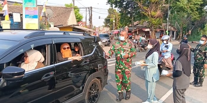 Caption : Koramil 0102 Cadasari bersama UPT Puskesmas Cigadung bagikan ribuan masker kepada pengendara