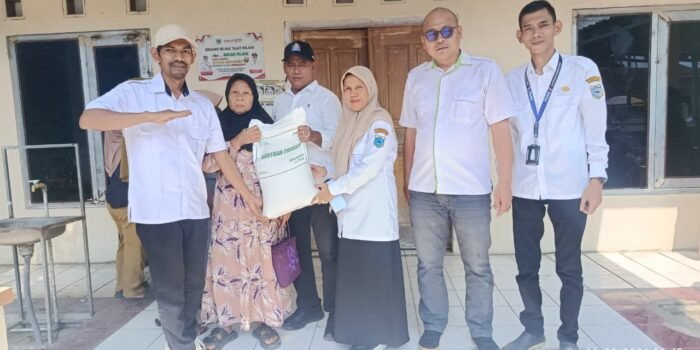 Caption : Warga Desa Purwaraja, Kecamatan Menes, menerima bantuan beras dari Pemerintah di kantor desa setempat.